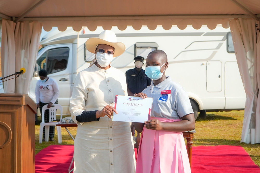 The First Lady awarding Judith, Head Girl of Scared Heart Sec. School with a certificate of excellence.